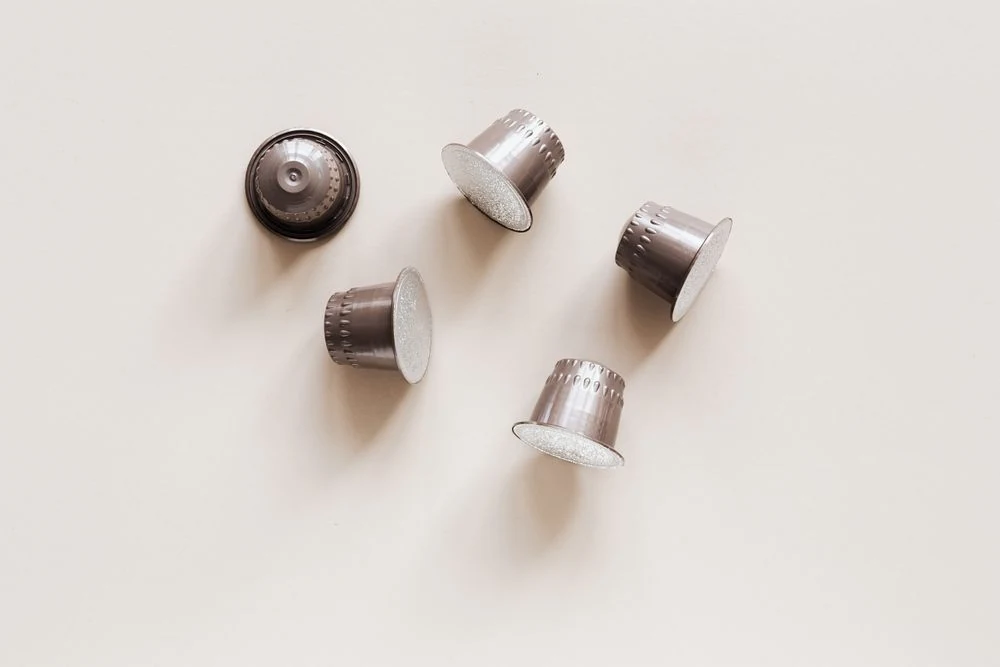 Silver coffee capsules on a light surface